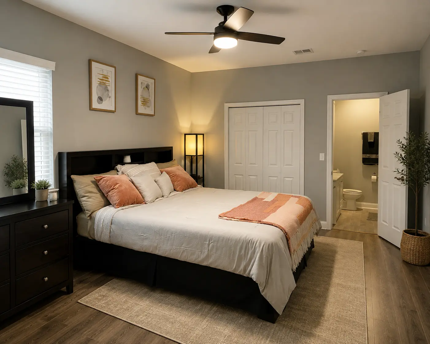 Furnished bedroom with warm bedding, dresser and mirror in a sunlit stay